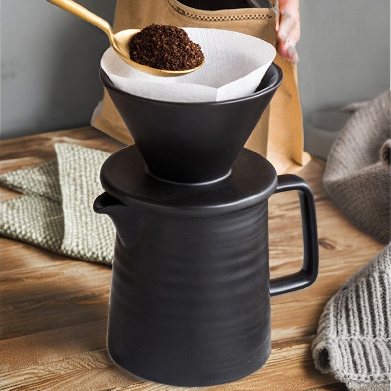 Moderna macchina da caffè in ceramica nera opaca impostata per versare nello stile di design del soggiorno
